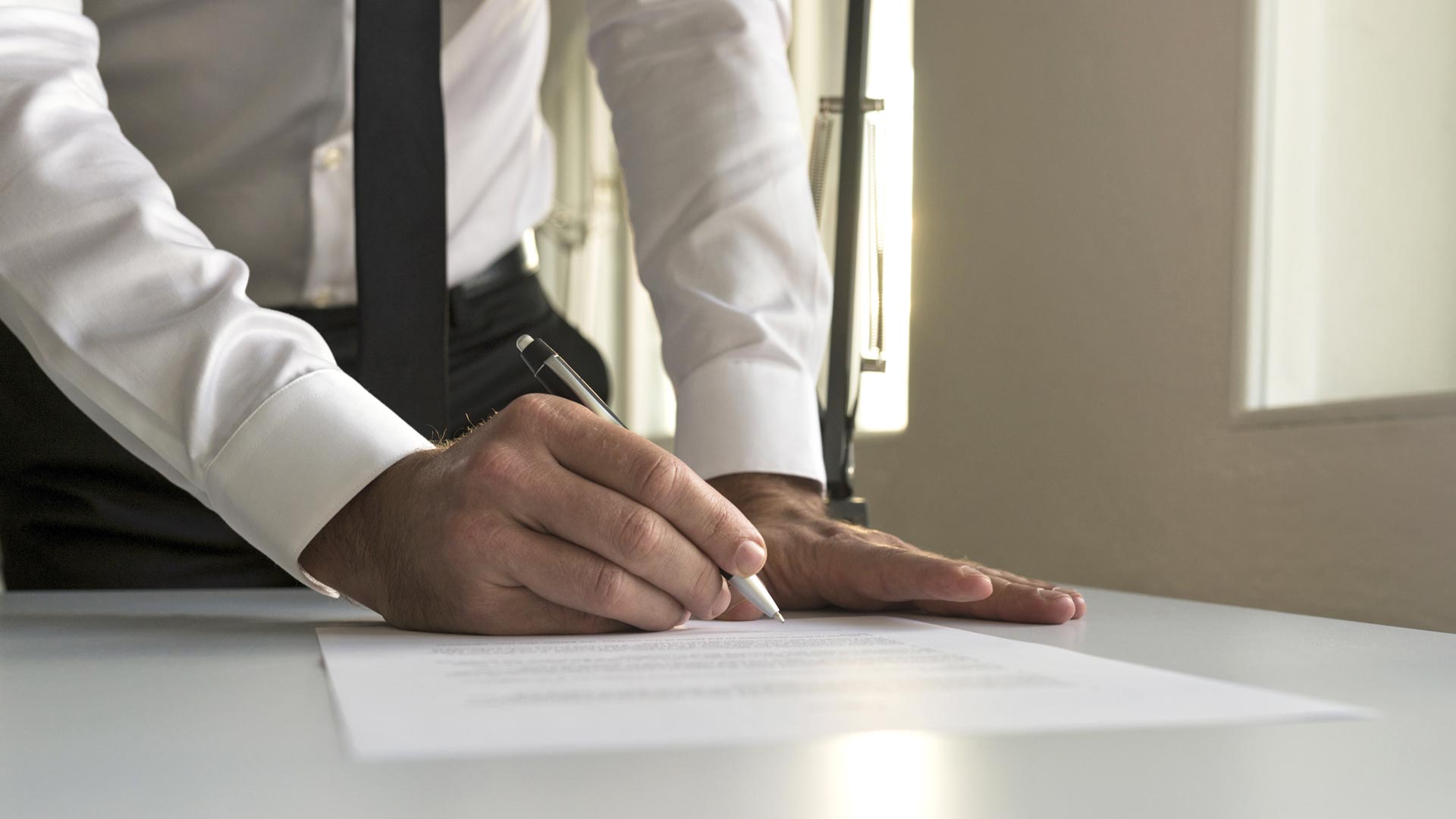 man signing papers